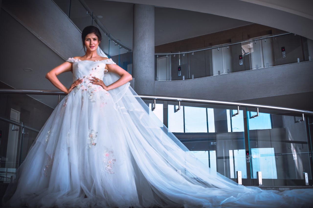 Stunning bride posing in a modern indoor setting with elegant wedding gown.